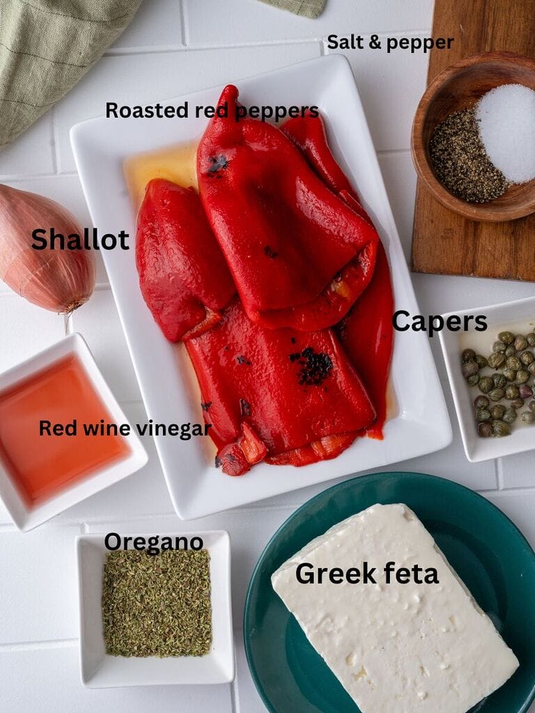 Ingredients for roasted red pepper and feta salad which include: jarred roasted red peppers; feta; shallot; red wine vinegar; oregano; feta, capers and salt and pepper.