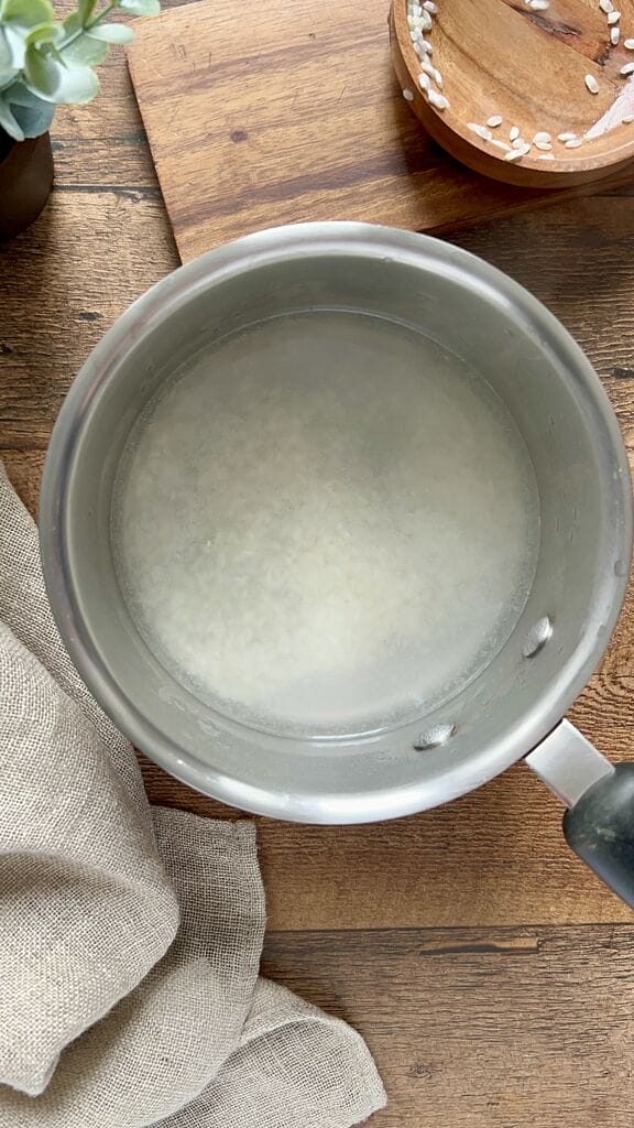 Cooking the rice in a stainless steel pot.