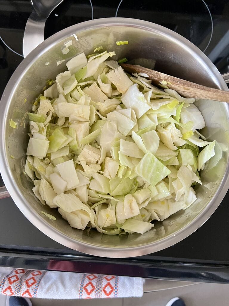 Showing the chopped cabbage in the pot.