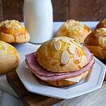 Tsoureki bread ham and cheese sandwich on a white plate.