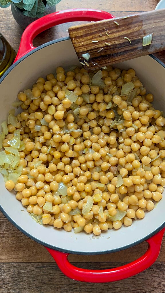 Combining the chickpeas with olive oil and onions.