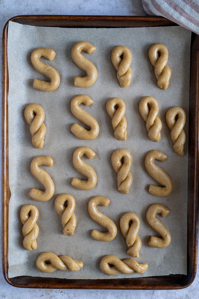 Formed koulourakia on a baking sheet.