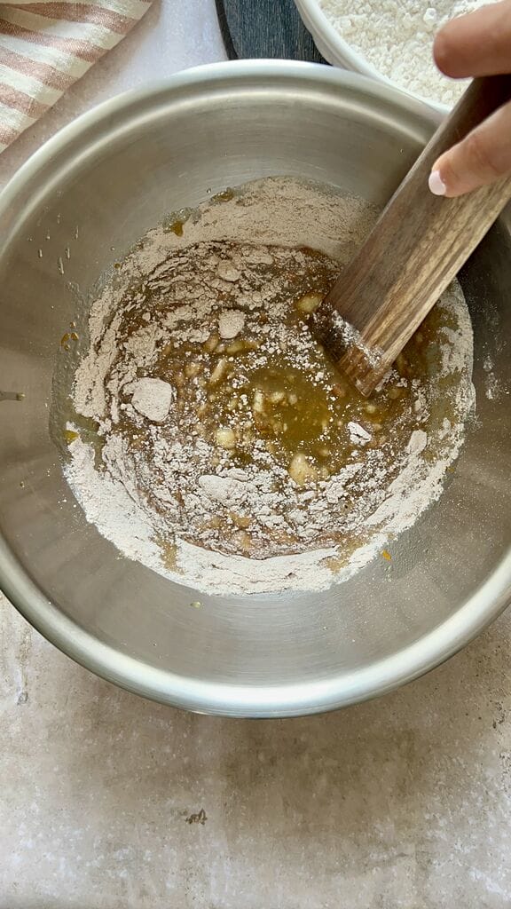Mixing the flour with the wet ingredients.