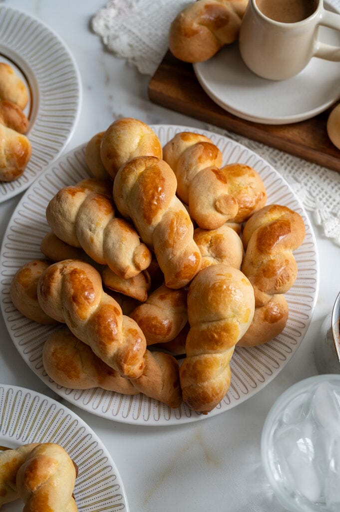 Koulourakia, a Greek cookie. Plated on a white platter with a gold trim.