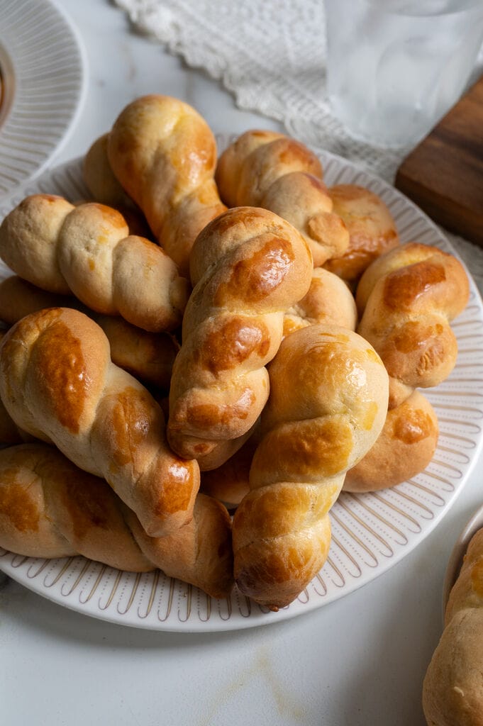 Koulourakia, a Greek cookie. Plated on a white platter with a gold trim.