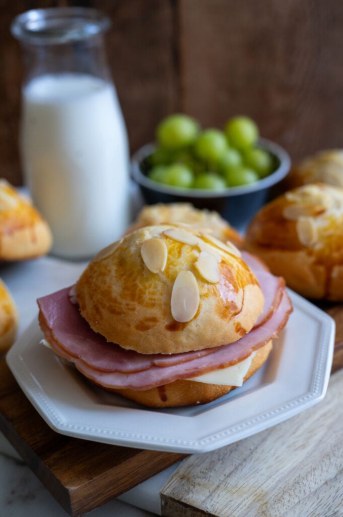 Tsoureki bread ham and cheese sandwich on a white plate.