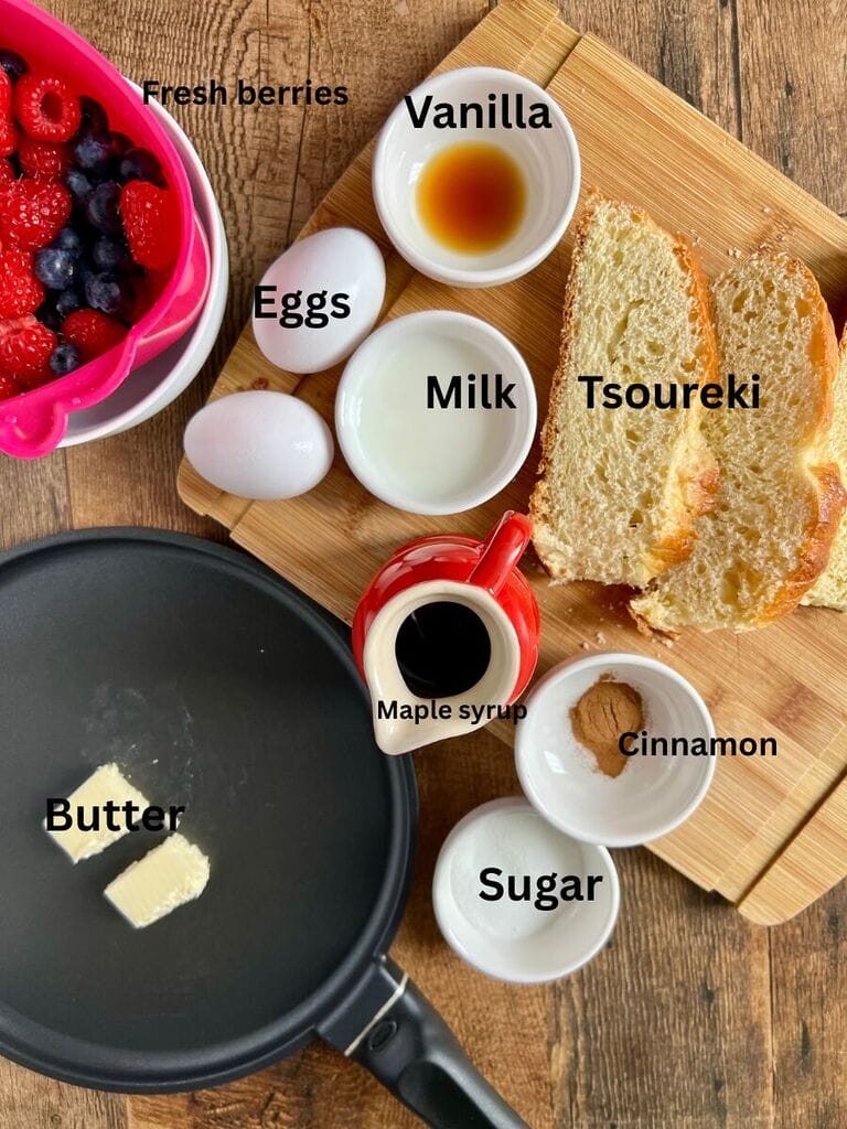Ingredients for the Tsoureki French toast which include: Tsoureki, eggs, milk, sugar, cinnamon, butter, vanilla extract, maple syrup and fresh berries.