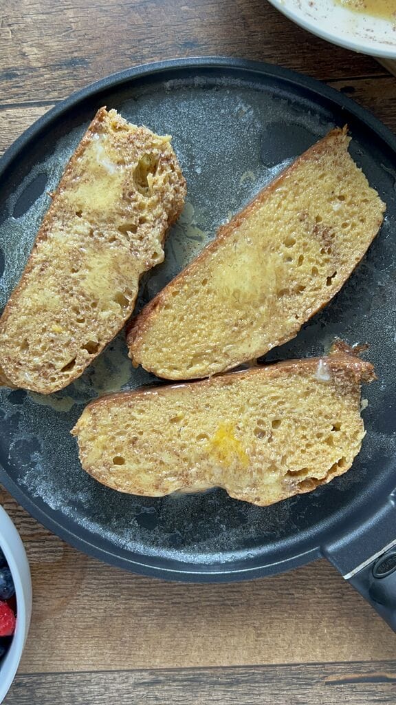 Frying the tsoureki French toast.