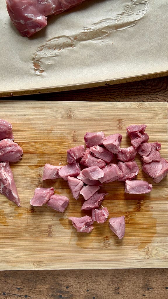 Cutting the pork pieces into 1 inch cubes.