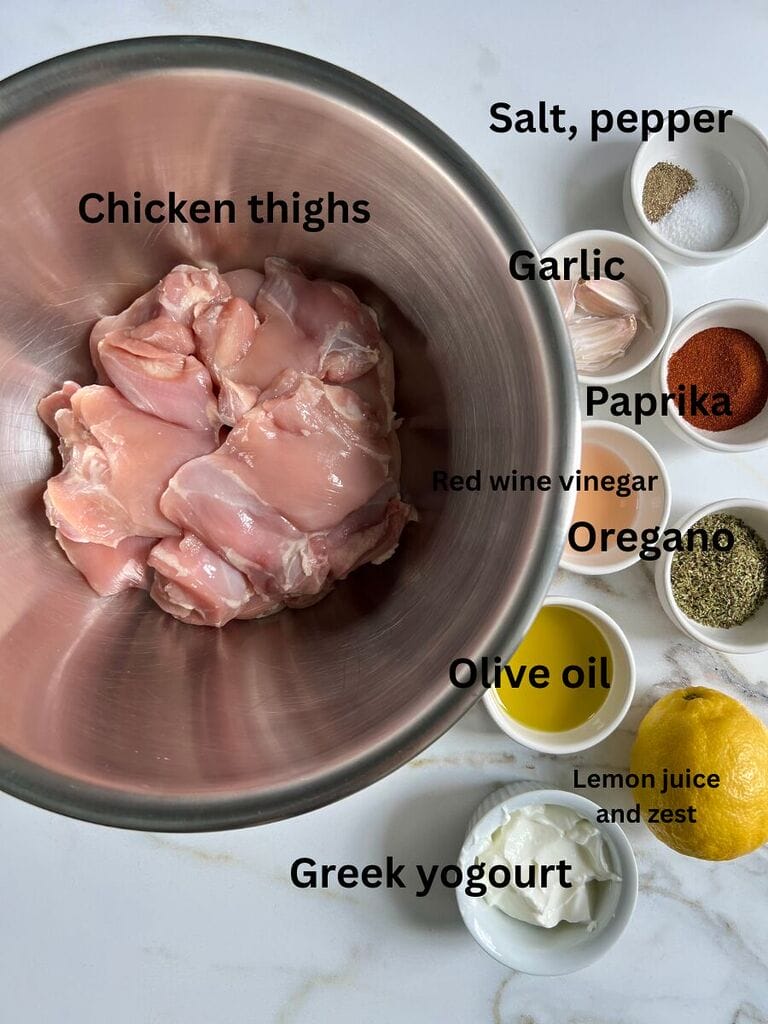Ingredients for the marinade, which include: Chicken thighs, Greek yogourt, salt, pepper, garlic, paprika, red wine vinegar, oregano, olive oil, lemon zest and lemon juice.