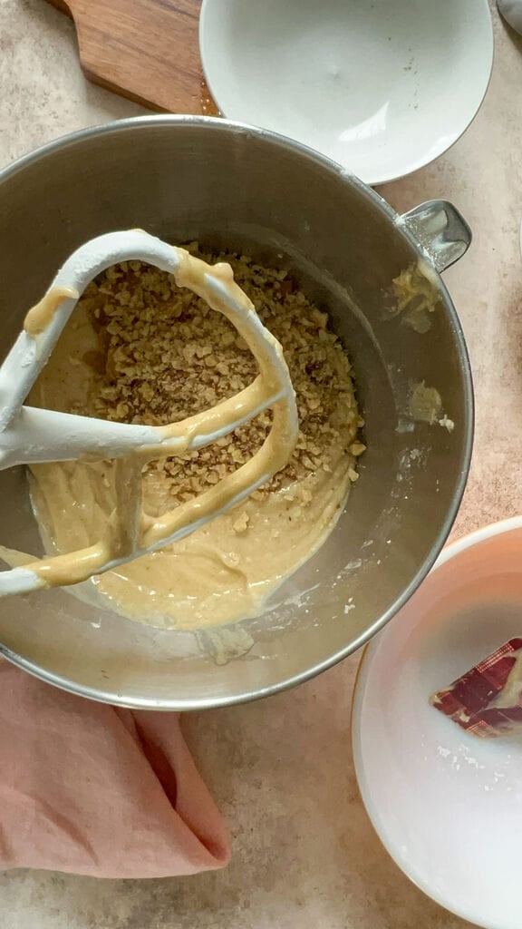 Mixing together the walnuts and the raisins to the batter.
