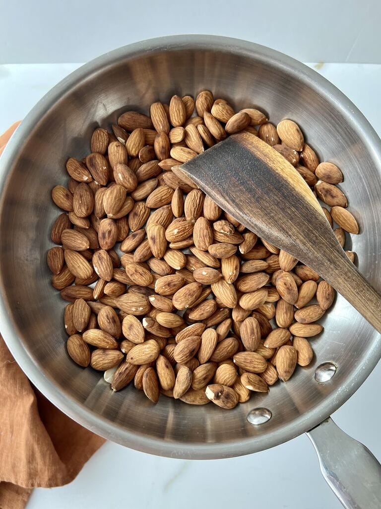 Toasting the almonds in a frying pan.