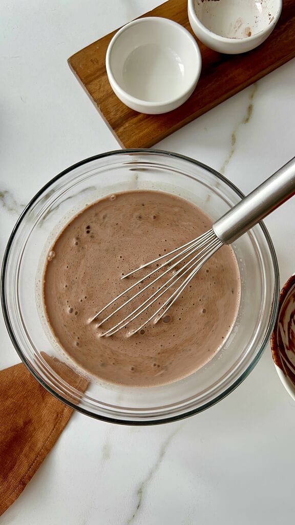 Whisking the milk with the cocoa mixture.