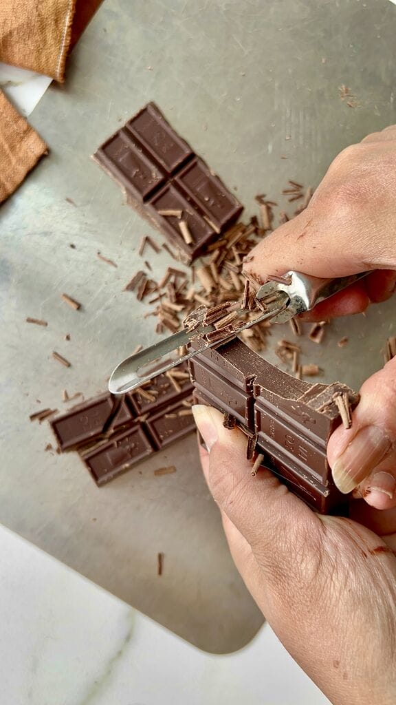 Shaving off chocolate pieces.