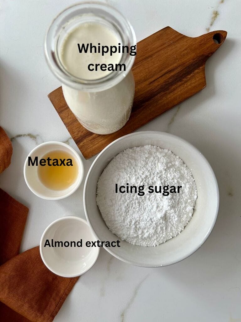 Ingredients to make the whipping cream which include: Whipping cream, metaxa, almond extract and Icing sugar.