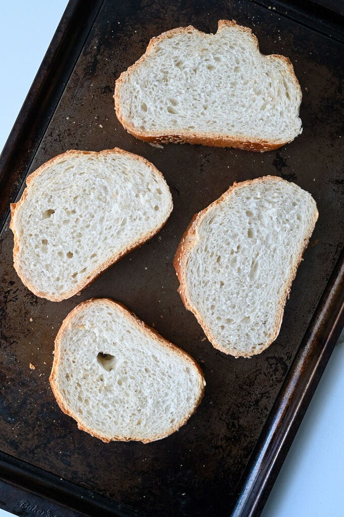 Slices of bread on a baking sheet.