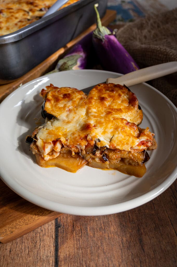 Eggplant, potato and mozzarella baked casserole plated on a gray plate.