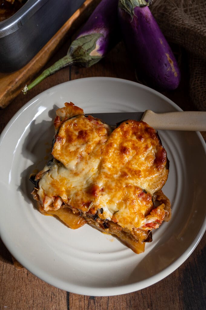 Eggplant, potato and mozzarella baked casserole plated on a gray plate.