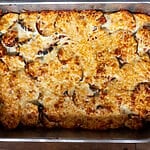 Eggplant, potato and mozzarella baked casserole in a stainless steel casserole dish.