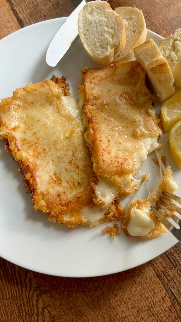 Cutting into a piece of the cheese saganaki.