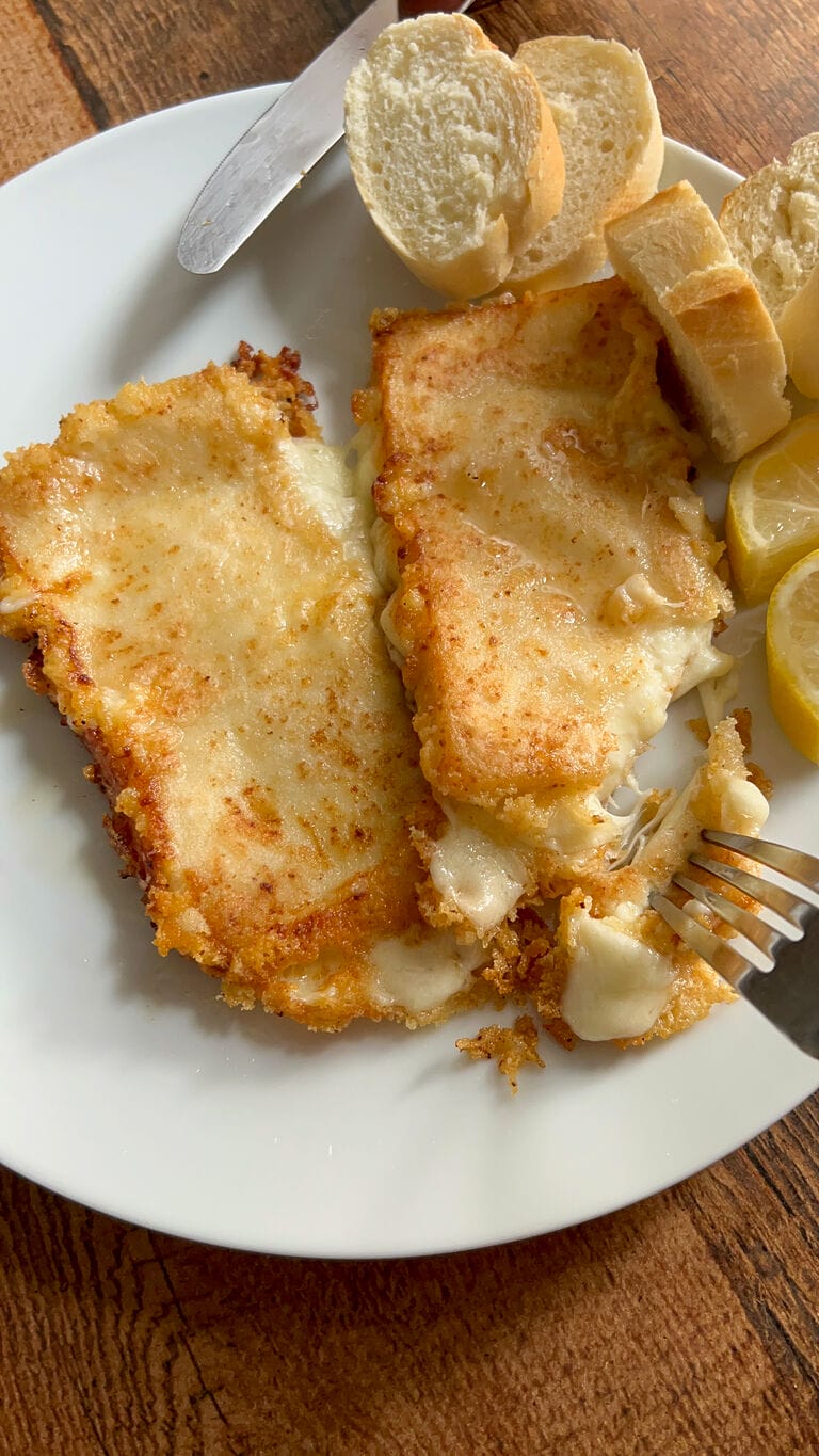 Cutting into a piece of the cheese saganaki.