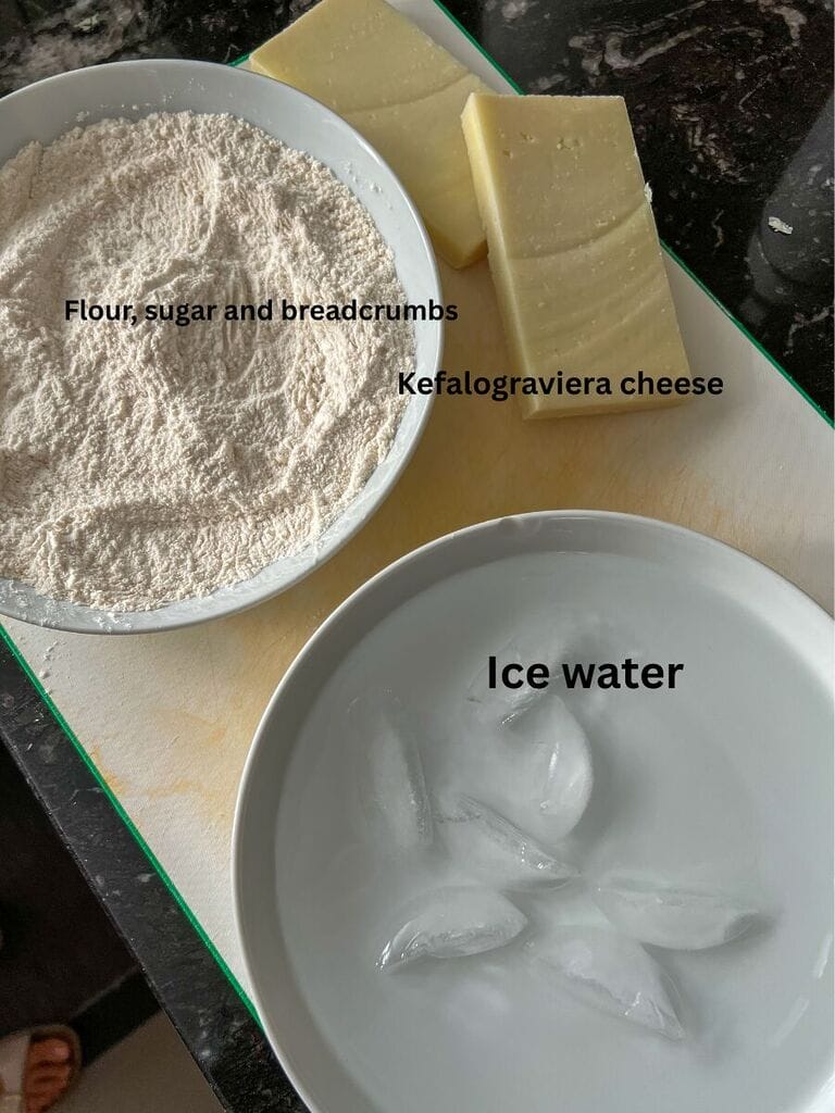 Ingredients for the cheese saganaki include: breadcrumbs, flour, sugar, ice water, and kefalograviera cheese.