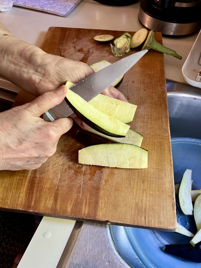 Slicing the eggplant pieces.