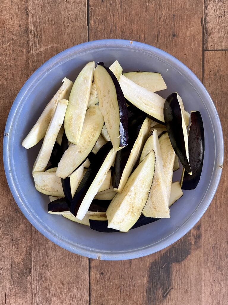 Eggplant wedges in a blue bowl.