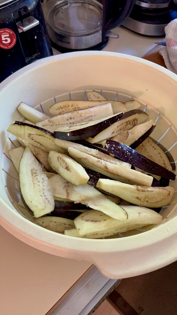 Letting the eggplant rest in a colander.