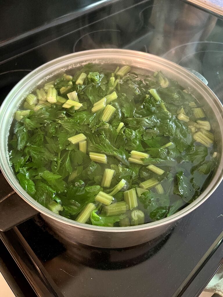 Blanching the celery leaves and stems.