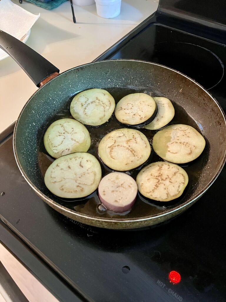 Frying the eggplant pieces.