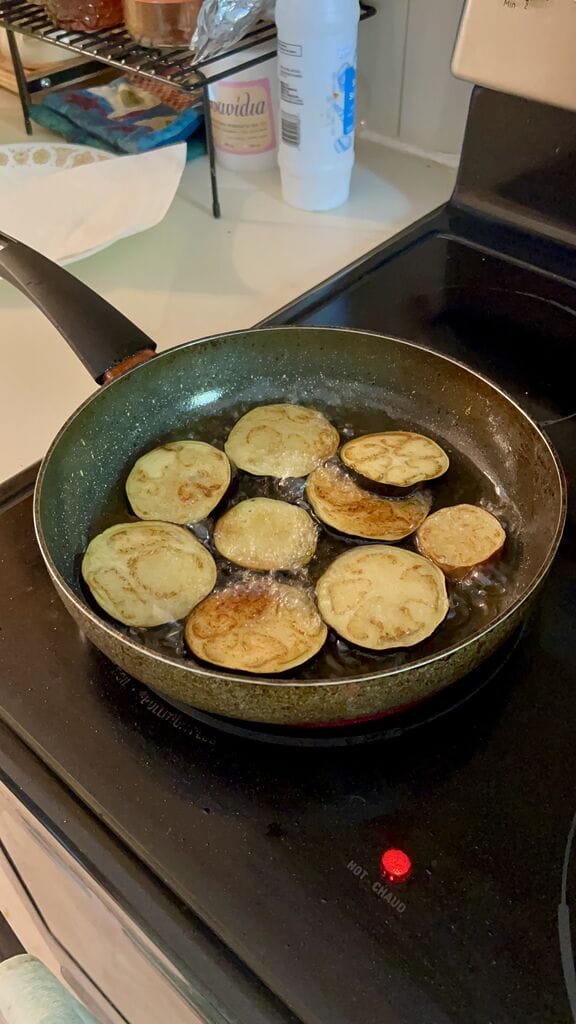 Frying the eggplant pieces.