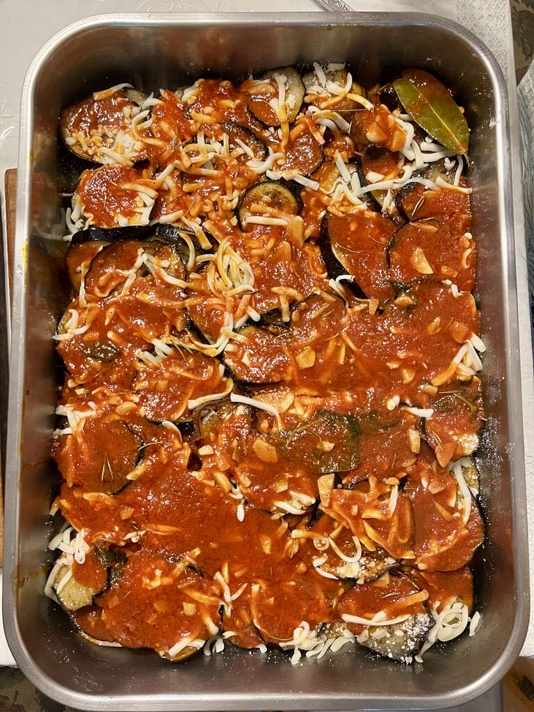 Eggplant, potato and mozzarella baked casserole in a stainless steel casserole pan, ready to bake.