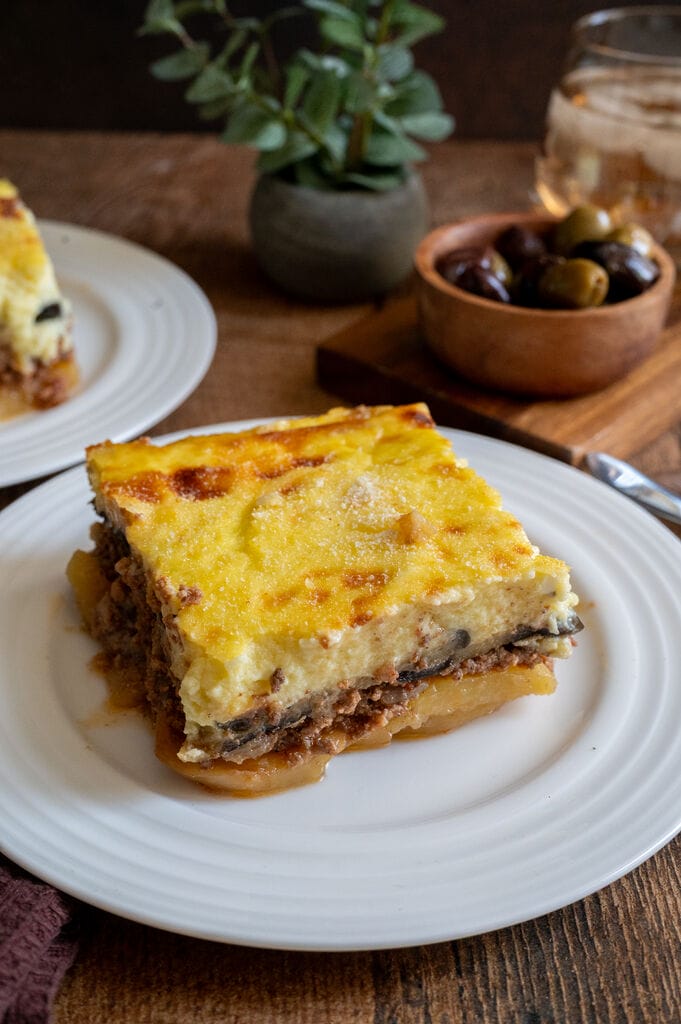 A piece of moussaka on a white plate.