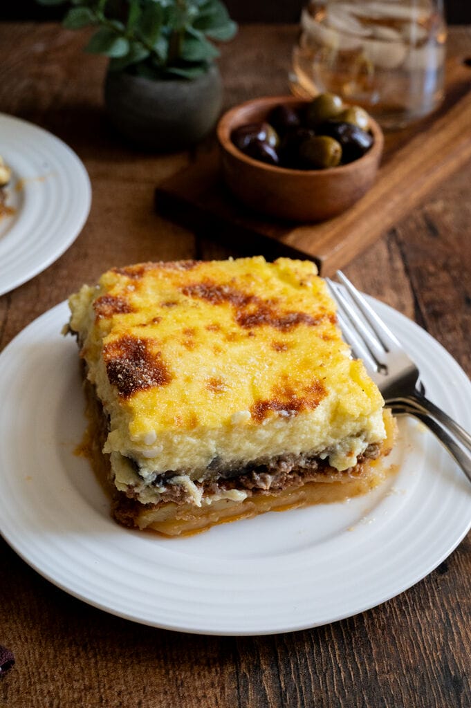 A piece of moussaka on a white plate.