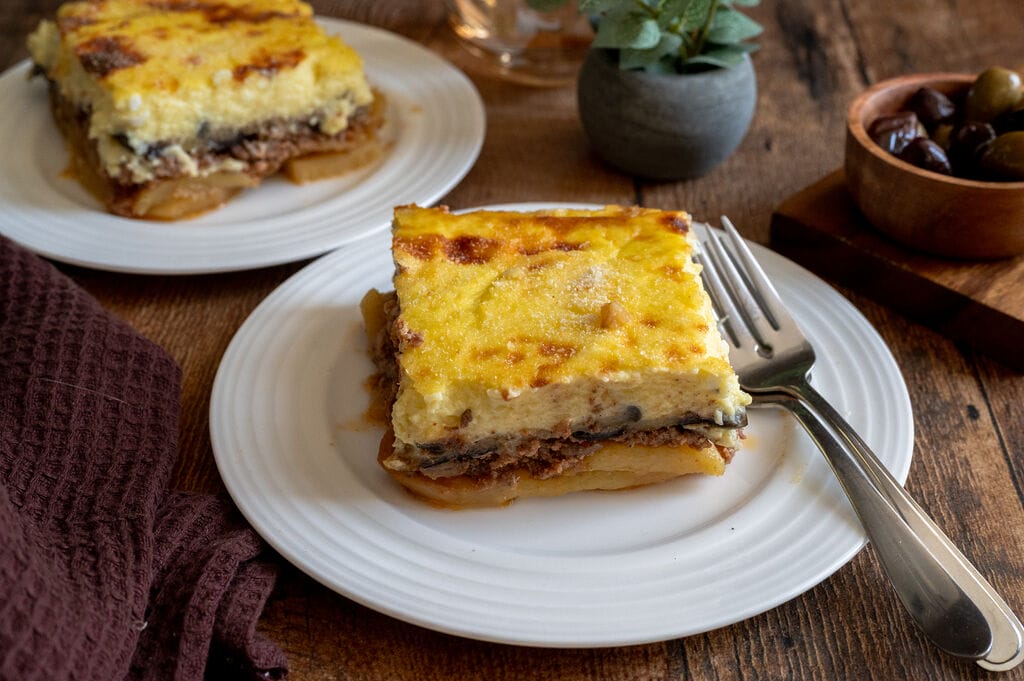 A piece of moussaka on a white plate.