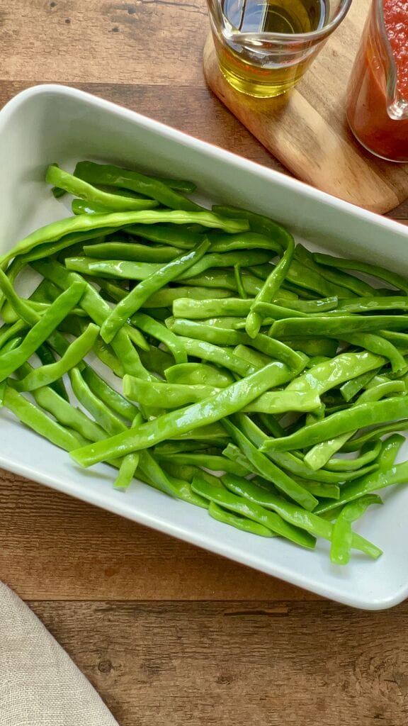 Green beans in a white casserole dish.