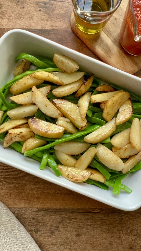 Green beans and potatoes in a white casserole dish.
