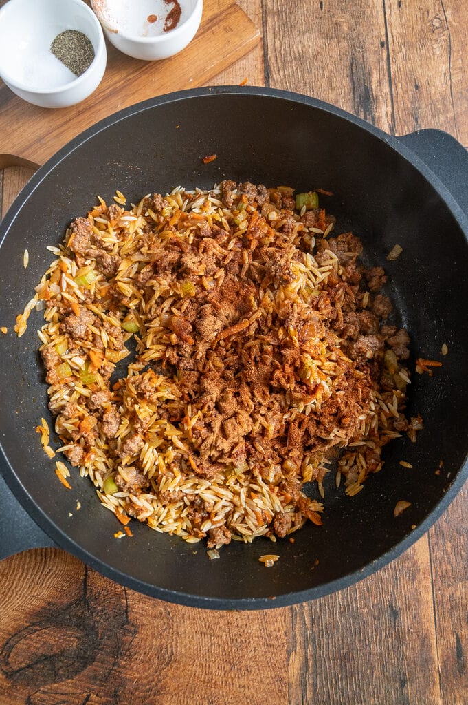 Adding the spices to the orzo mixture.
