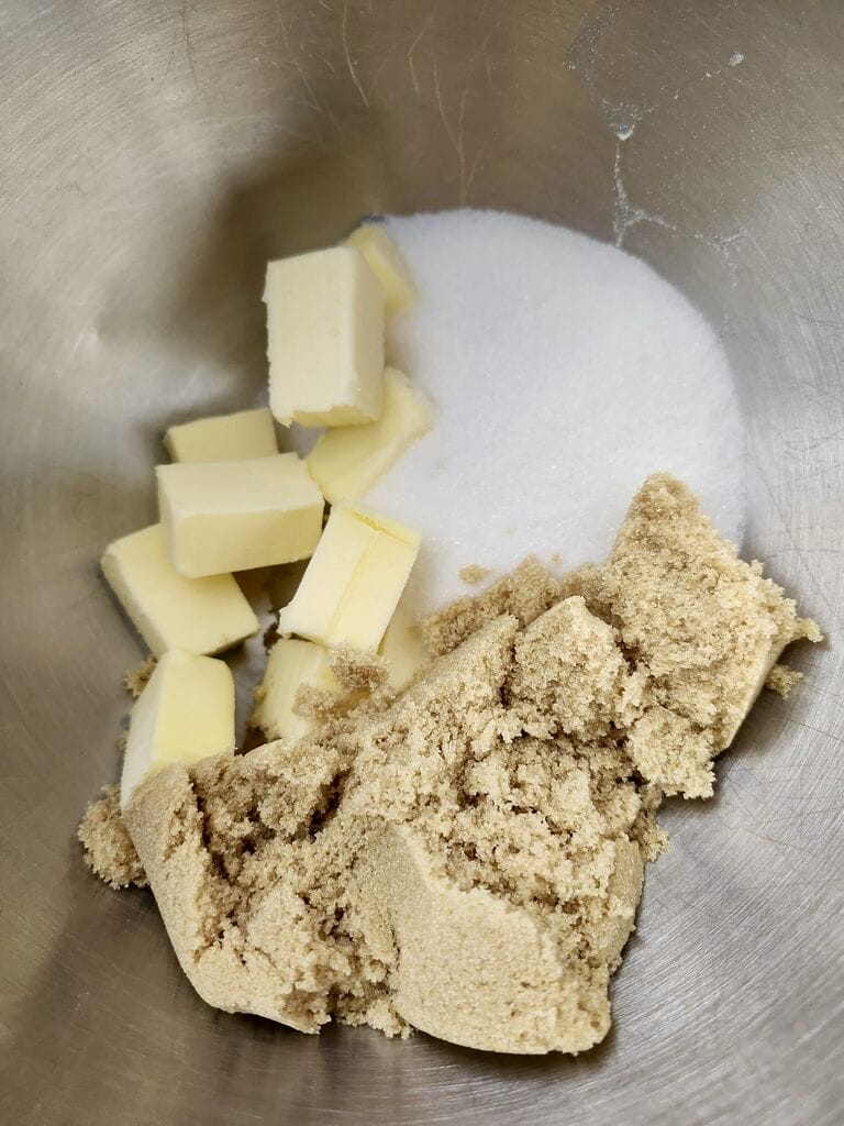 Combining brown sugar with butter and white sugar.