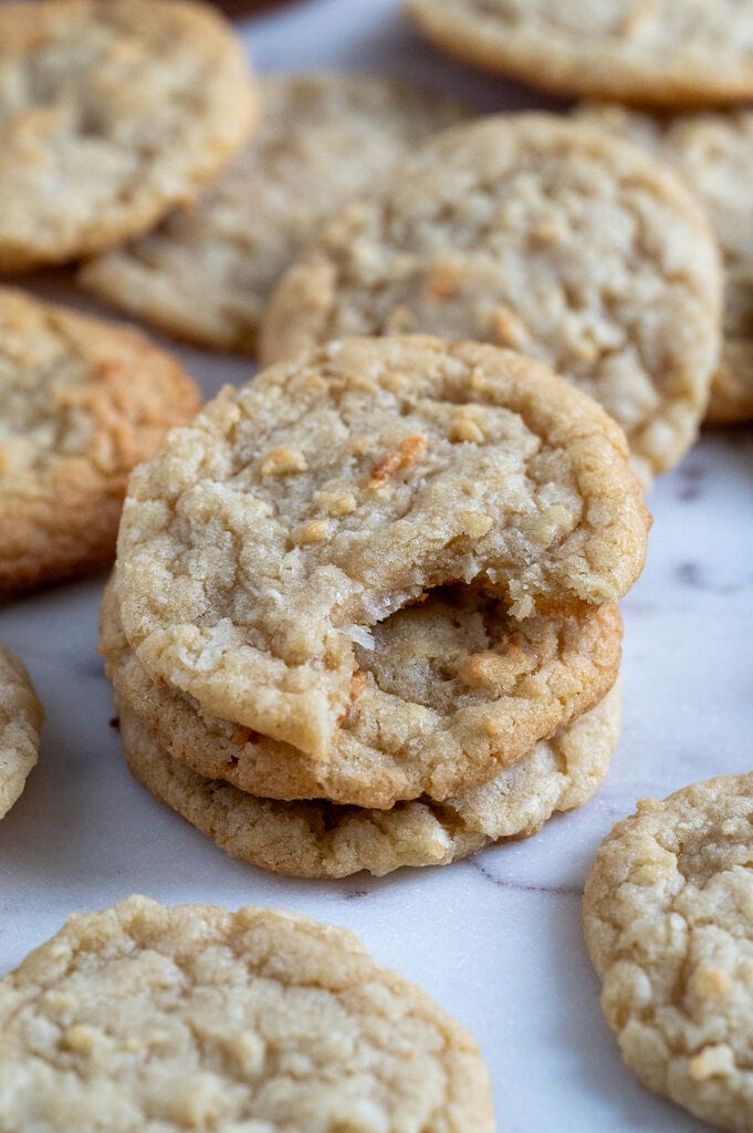Chewy coconut cookies displayed on a marble board.