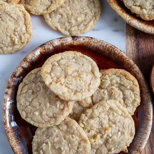 Chewy coconut cookies displayed on a marble board.