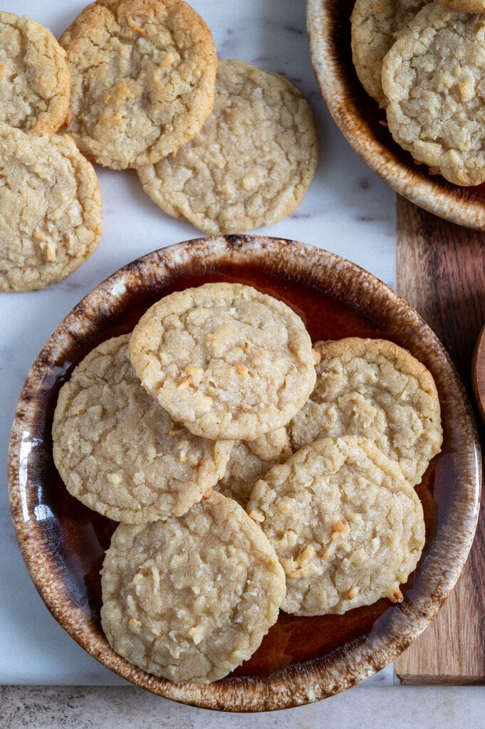 Chewy coconut cookies displayed on a marble board.