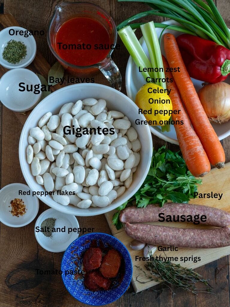 Ingredients which include: Gigantes, water, olive oil, Tomato sauce, Greek sausage, oregano, sugar, salt, pepper, red pepper flakes, tomato paste, parsley, garlic, fresh thyme springs, celery, carrots, lemon zest, red pepper, green onions and red pepper.