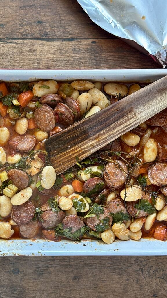 Greek Baked Gigantes with Sausage (Loukaniko), in a roasting pan ready to go in oven.