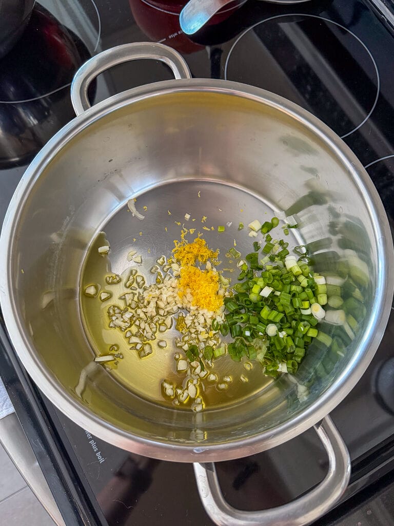 Sautéing the garlic, the green onions and lemon zest in the olive oil.