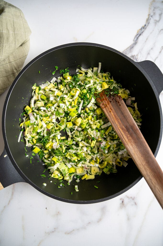 Sautéing the spinach with the leek, shallots and garlic.