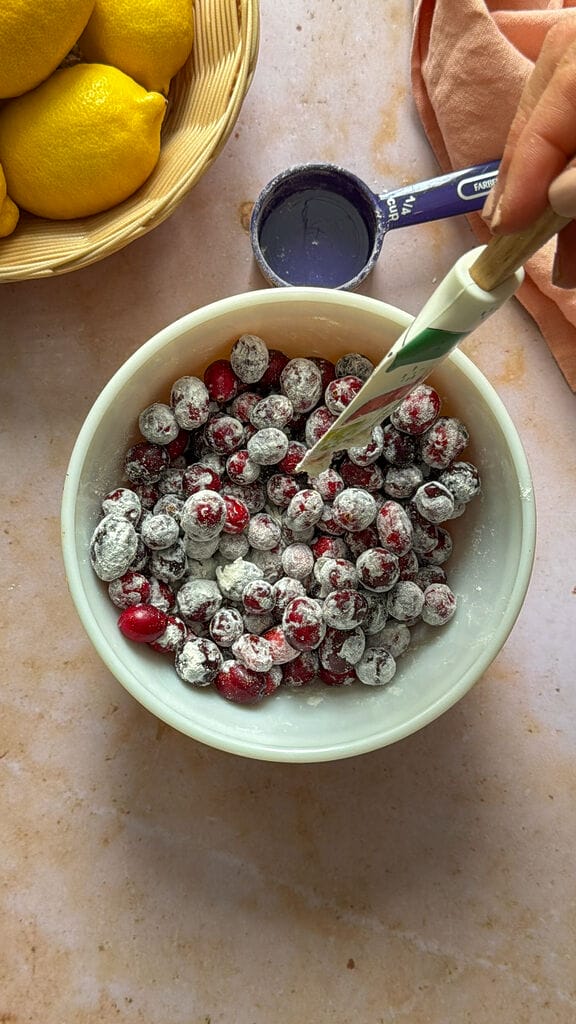 Mixing the cranberries with some flour.