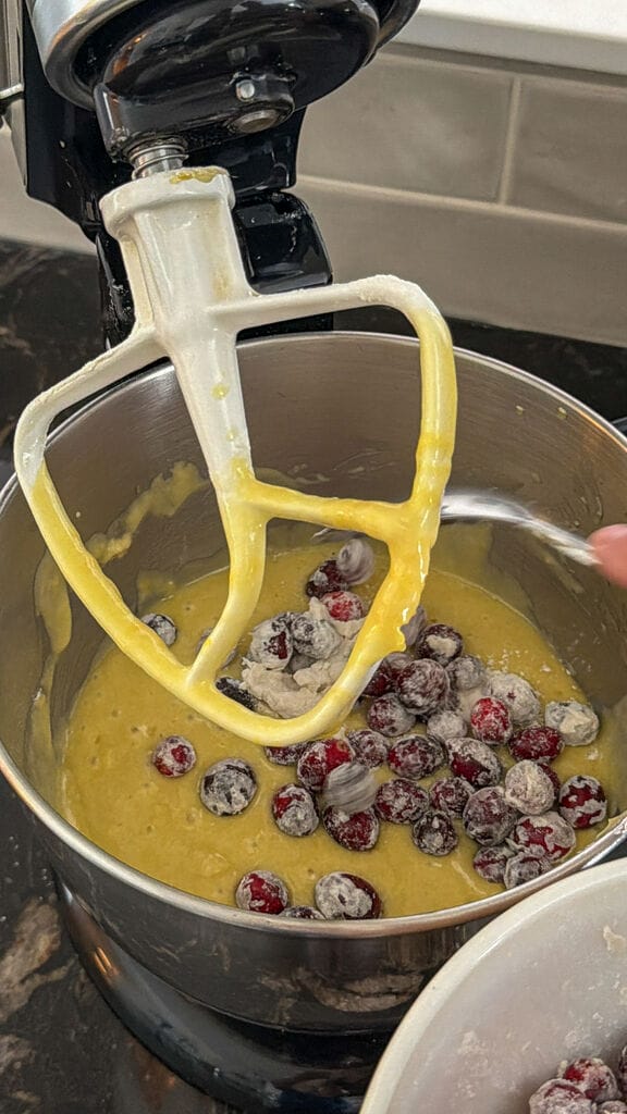 Combining the cranberries into the cake batter.