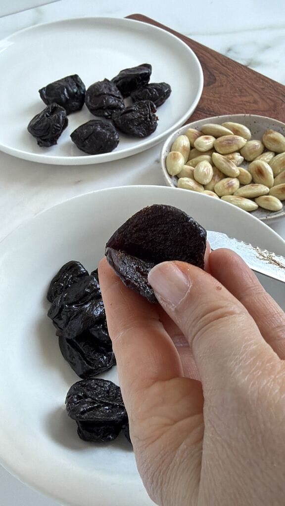 Cutting open the prune to stuff.